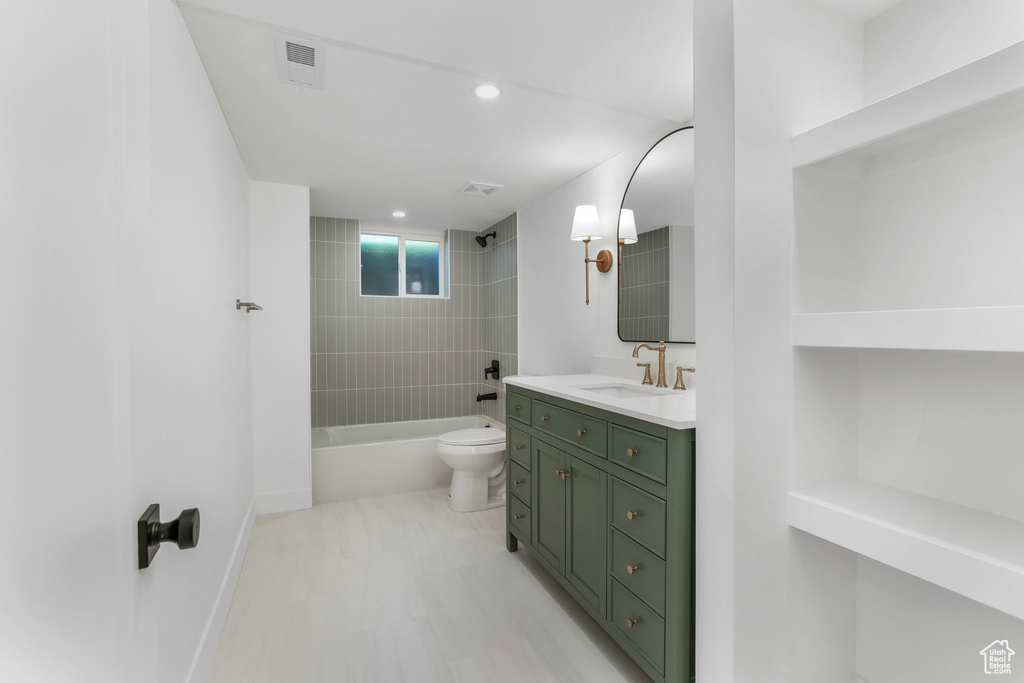 Bathroom with tub / shower combination, toilet, vanity, baseboards, and recessed lighting