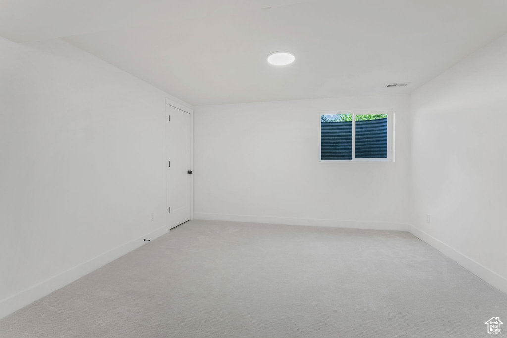 Unfurnished room with baseboards and light colored carpet