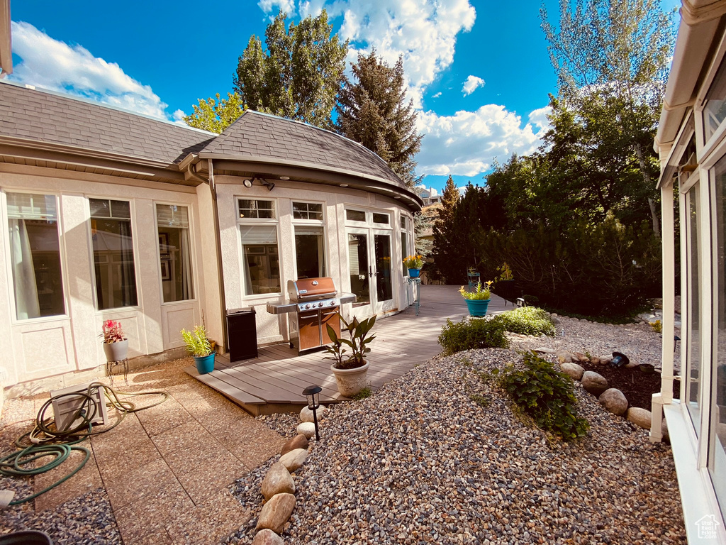 View of patio with grilling area, a wooden deck, and french doors