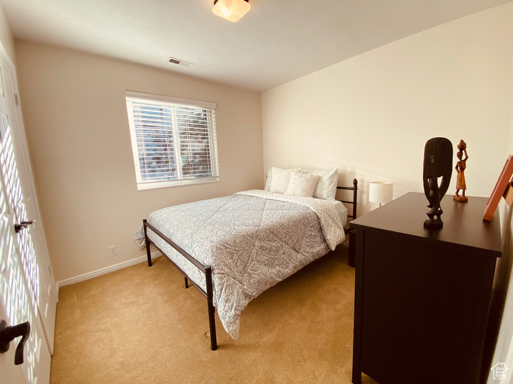 Bedroom featuring light colored carpet and baseboards