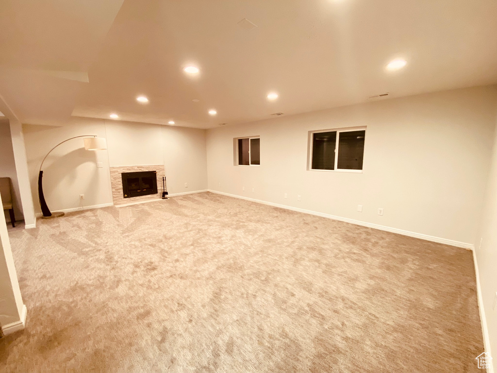 Finished basement with recessed lighting, light carpet, a fireplace, and baseboards