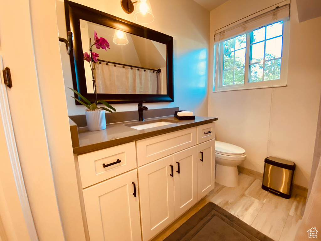 Bathroom featuring vanity, toilet, baseboards, and a shower with shower curtain