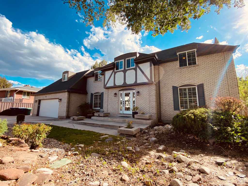 View of front of house featuring brick siding, an attached garage, and concrete driveway