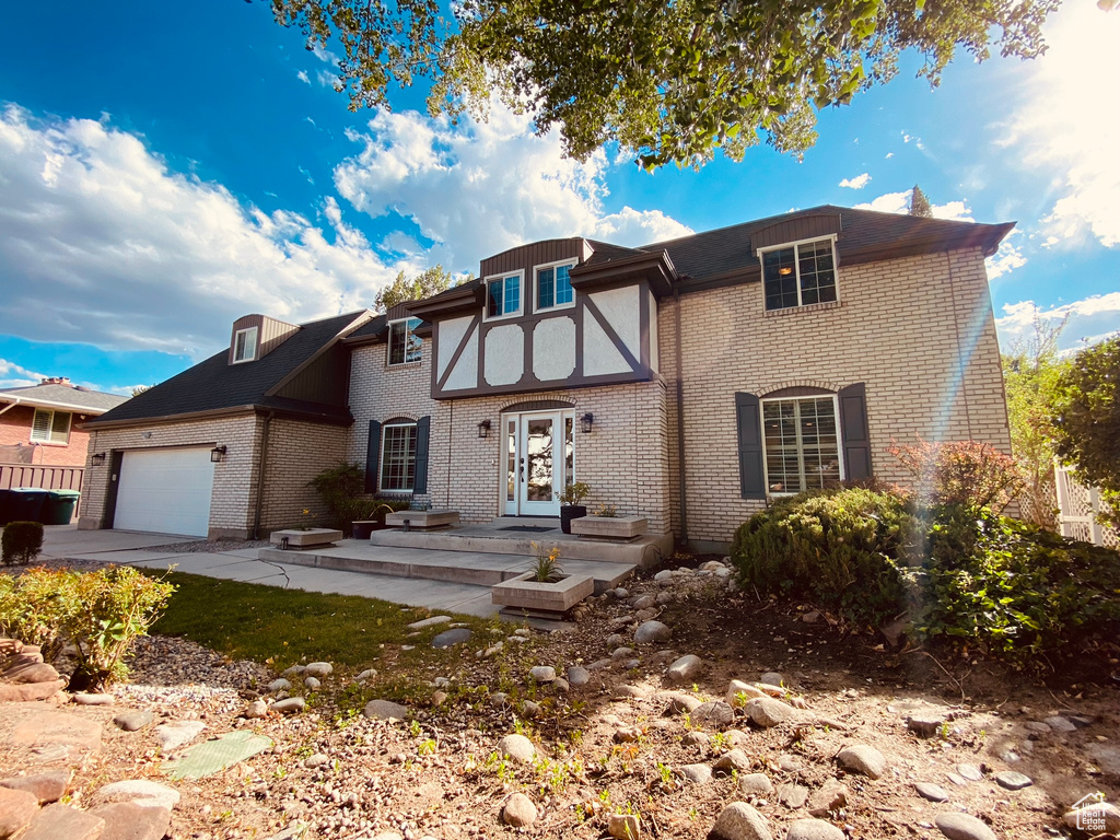 View of front of house featuring brick siding, a garage, and concrete driveway