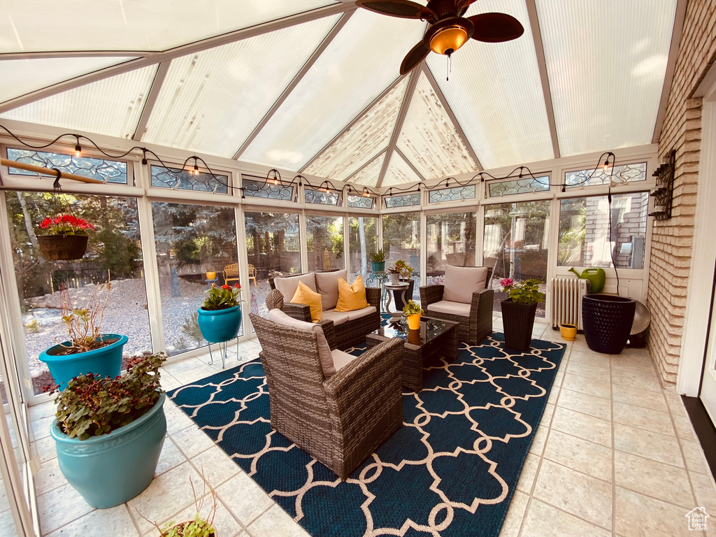 Sunroom / solarium with an outdoor hangout area, ceiling fan, and radiator heating unit
