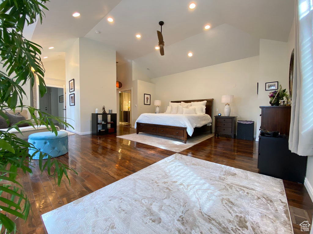 Bedroom with wood finished floors, high vaulted ceiling, recessed lighting, and baseboards