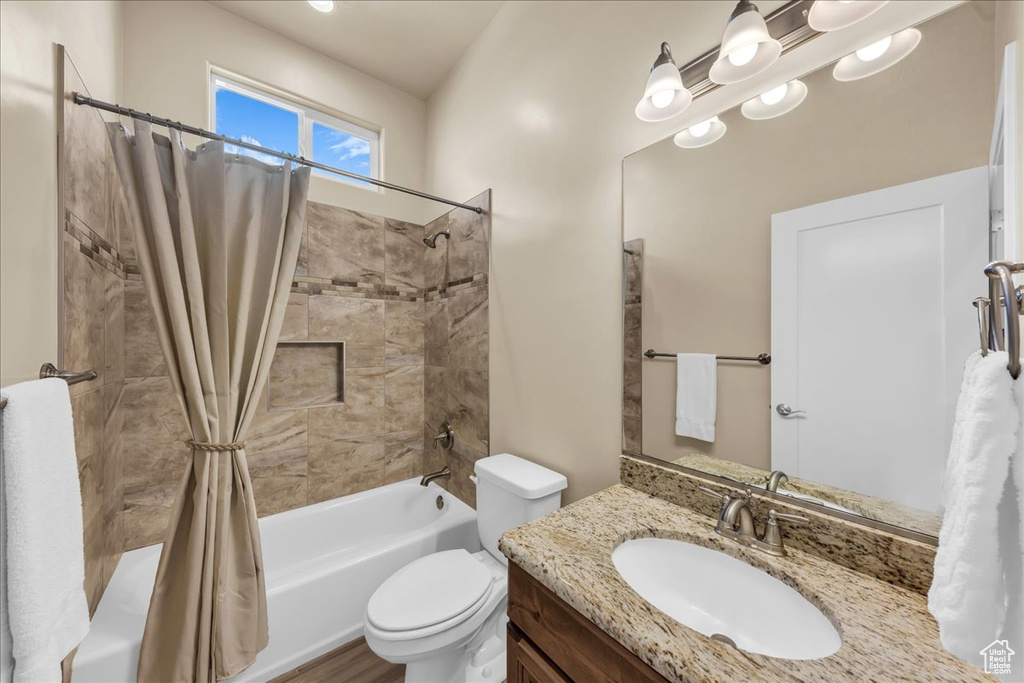 Bathroom with shower / tub combo with curtain, toilet, and vanity