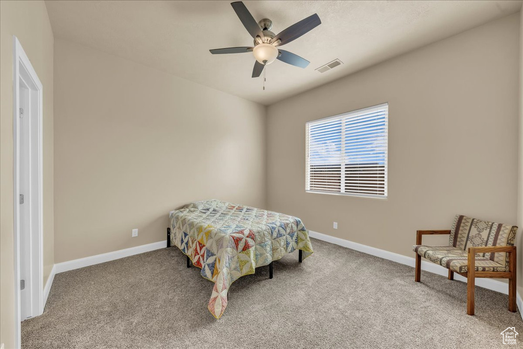 Carpeted bedroom featuring baseboards and ceiling fan
