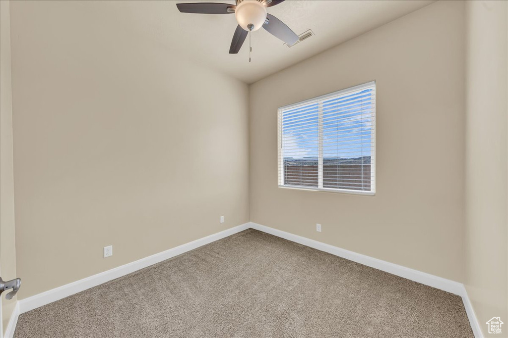 Unfurnished room with carpet floors, ceiling fan, and baseboards