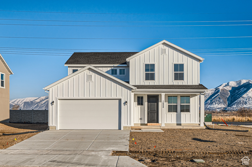 Modern inspired farmhouse featuring board and batten siding, a mountain view, and concrete driveway
