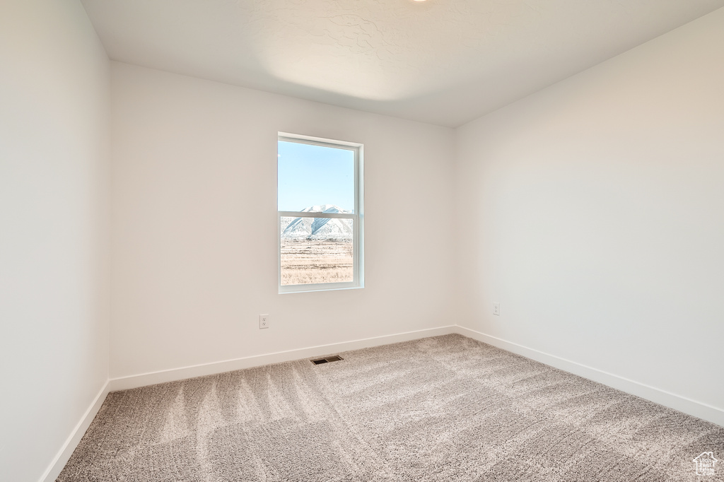 Carpeted empty room with baseboards