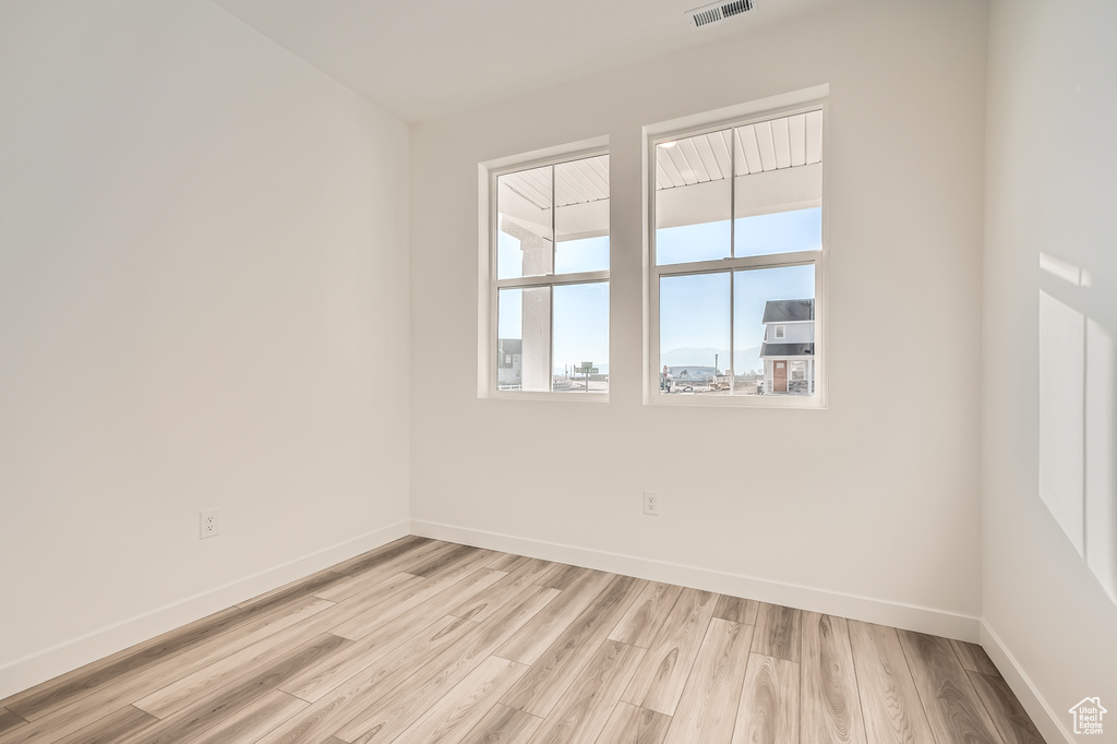 Spare room featuring light wood-type flooring and baseboards