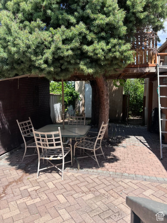 View of patio with outdoor dining space, an outdoor structure, and a storage shed