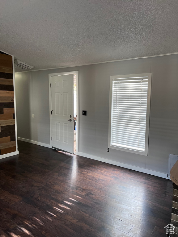 Foyer featuring wood finished floors, a textured ceiling, and baseboards