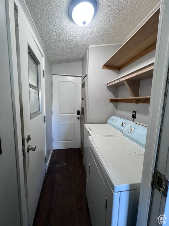 Clothes washing area featuring separate washer and dryer, a textured ceiling, and dark wood-style floors
