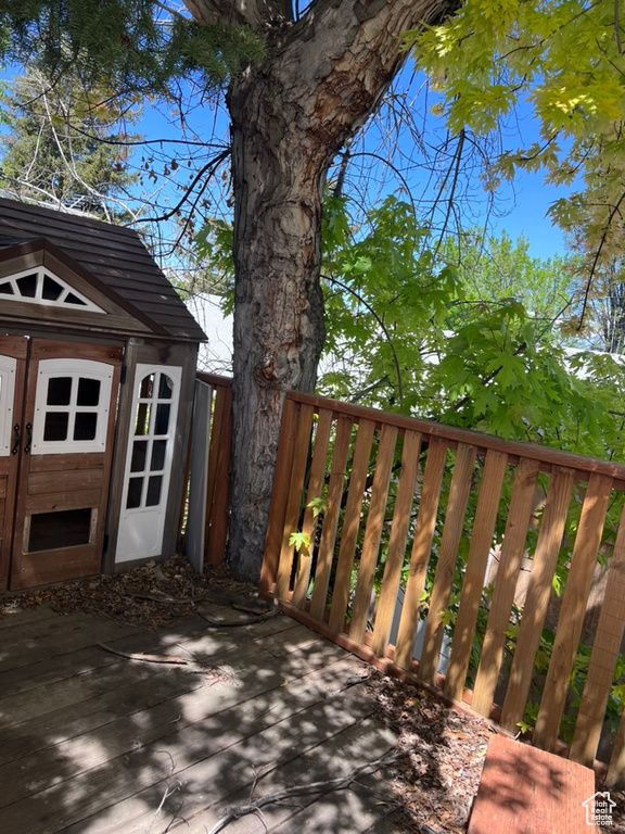 Wooden terrace featuring an outbuilding and a storage shed