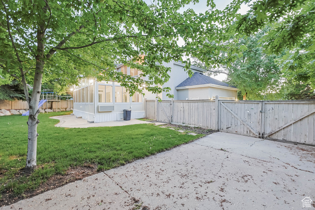 View of yard with a gate and a sunroom