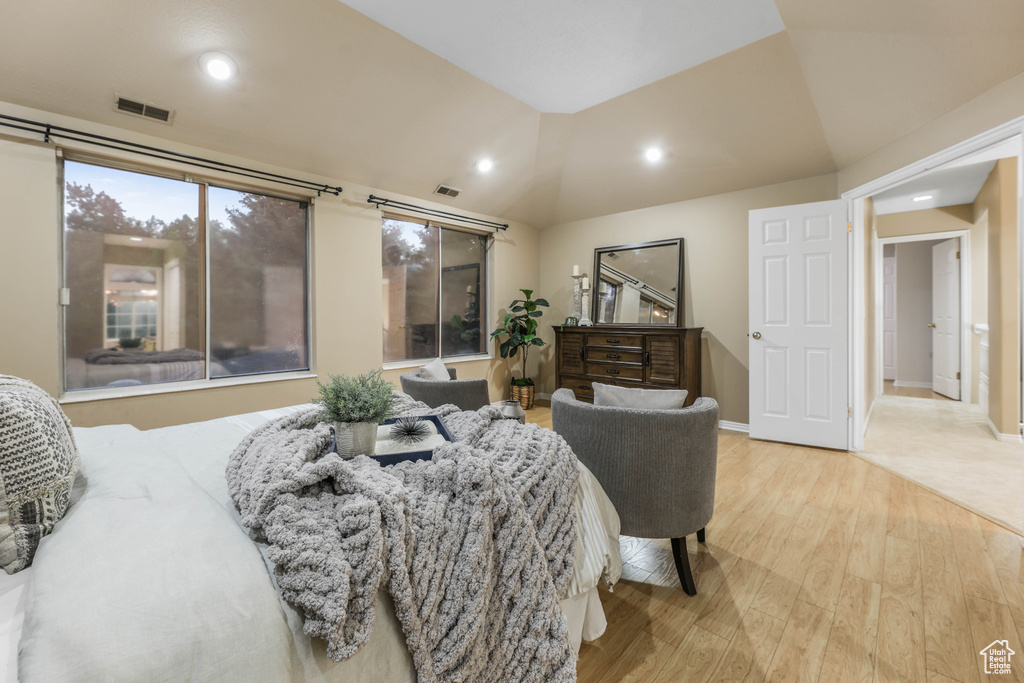 Bedroom with wood finished floors, vaulted ceiling, recessed lighting, and baseboards