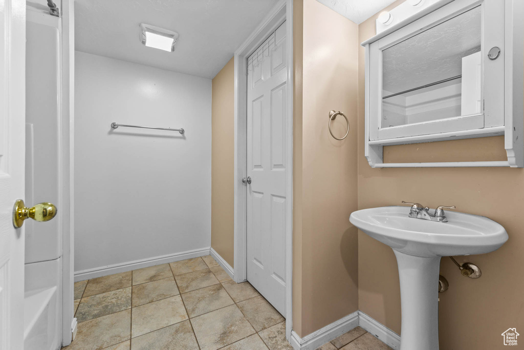 Bathroom featuring baseboards and a sink