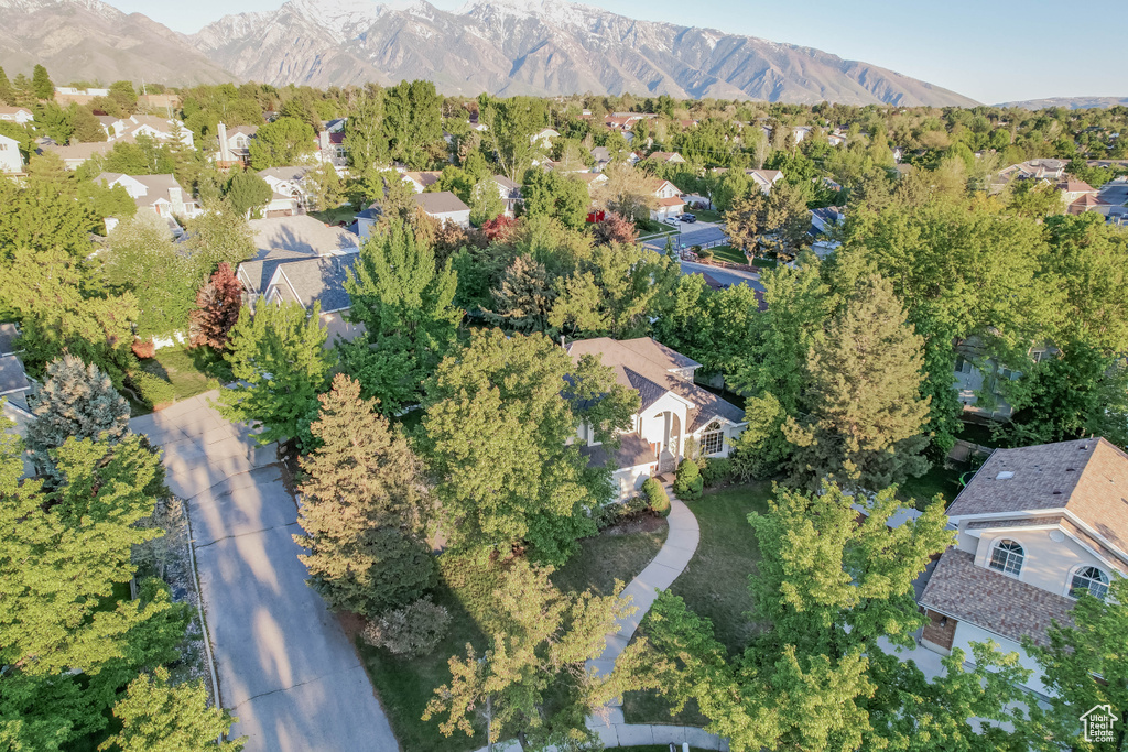 Aerial view of property and surrounding area with nearby suburban area and a mountain backdrop