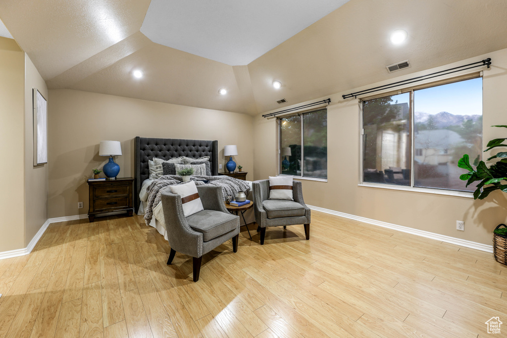 Bedroom with wood finished floors, baseboards, lofted ceiling, and recessed lighting
