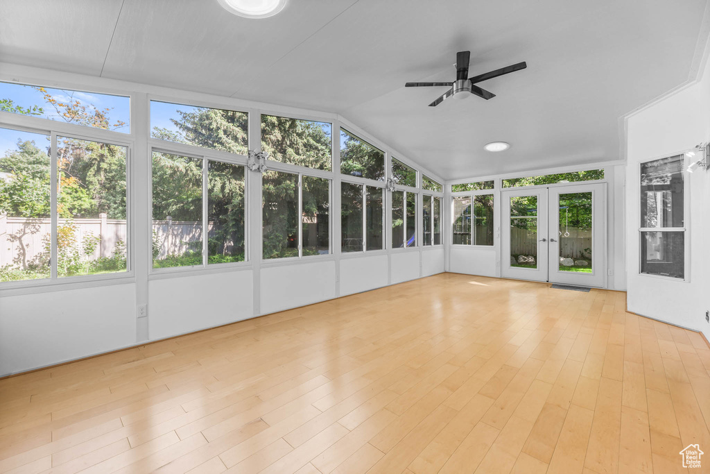 Unfurnished sunroom with french doors, lofted ceiling, and wood finished floors