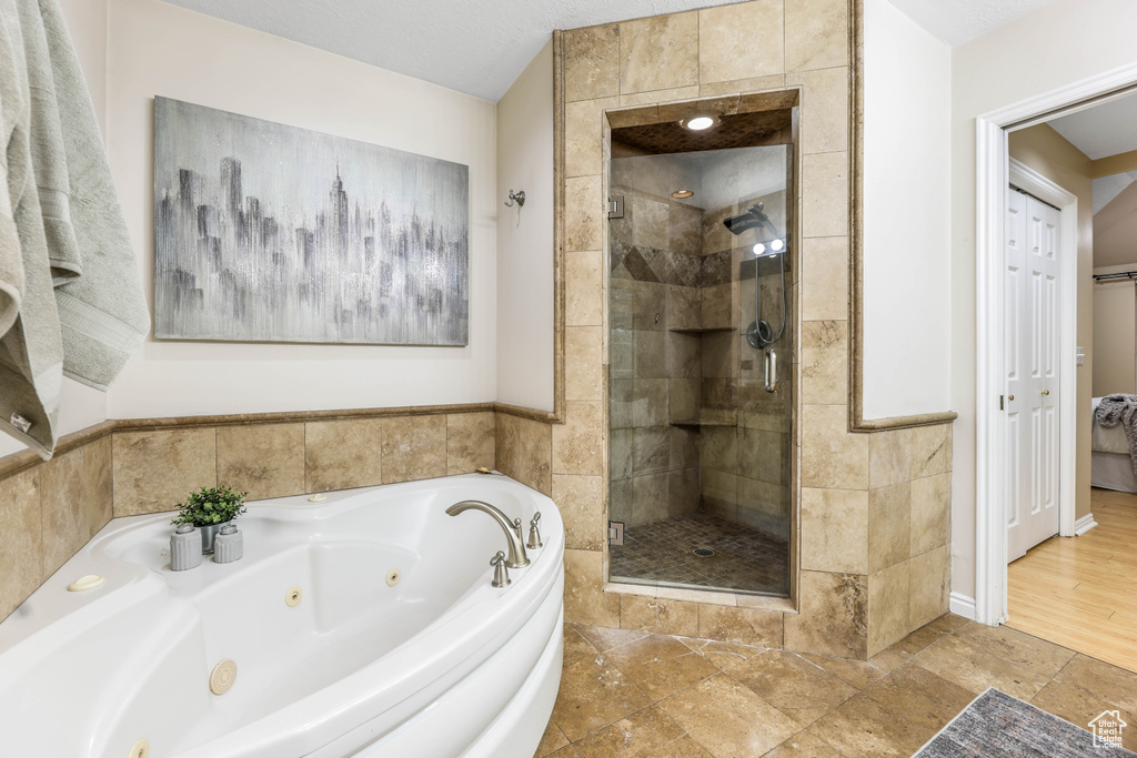 Bathroom with a stall shower and a tub with jets