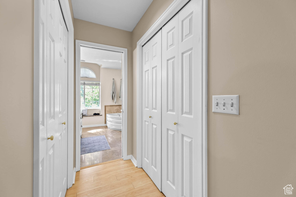 Hall with light wood-type flooring and baseboards