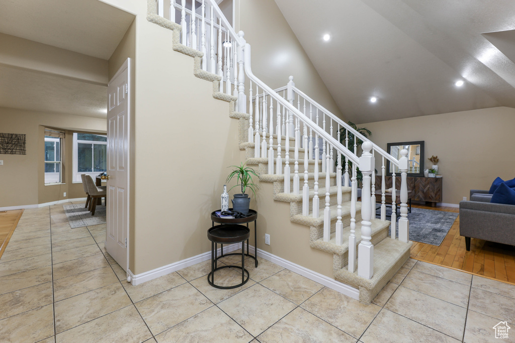 Stairs with tile patterned flooring, baseboards, recessed lighting, and vaulted ceiling