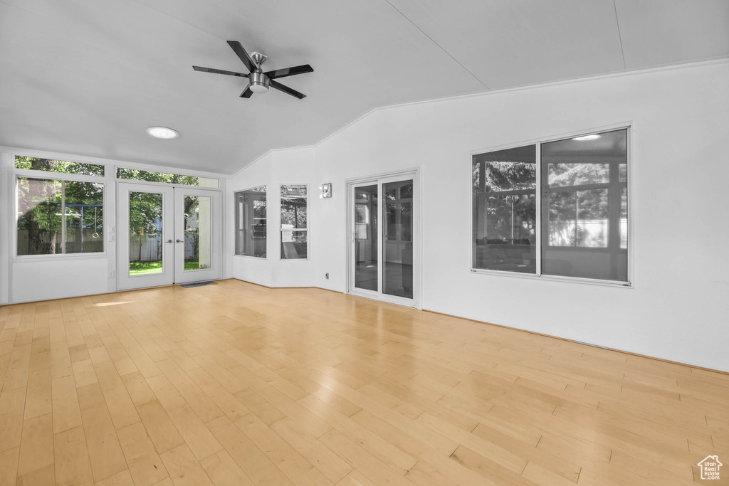 Unfurnished sunroom featuring french doors and lofted ceiling