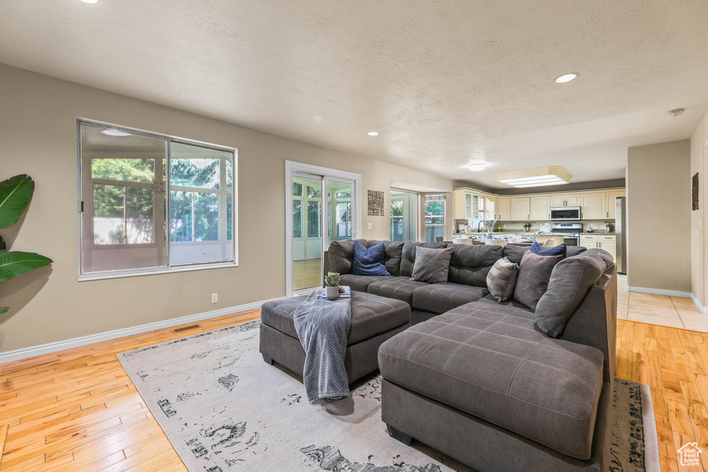Living area featuring light wood-style flooring, baseboards, and recessed lighting