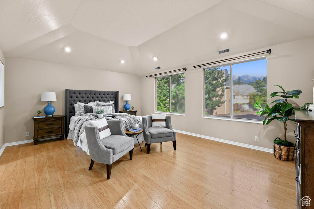 Bedroom with light wood finished floors, baseboards, lofted ceiling, and recessed lighting