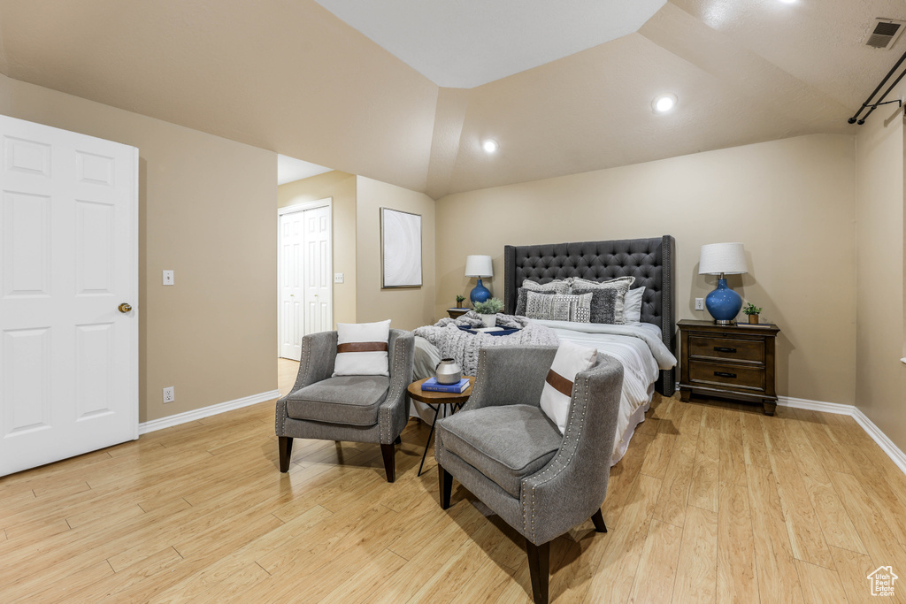 Bedroom featuring light wood-type flooring, baseboards, recessed lighting, lofted ceiling, and a closet