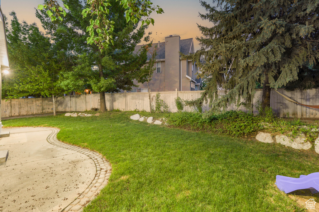 Yard at dusk featuring a patio area