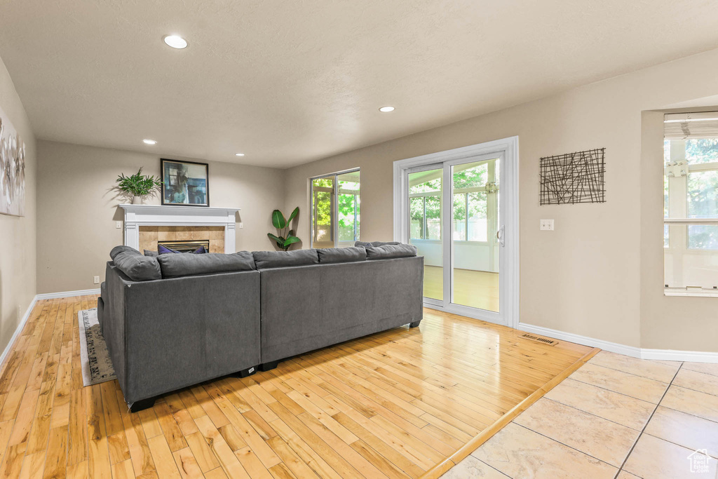 Living area featuring light wood-style floors, baseboards, plenty of natural light, and recessed lighting