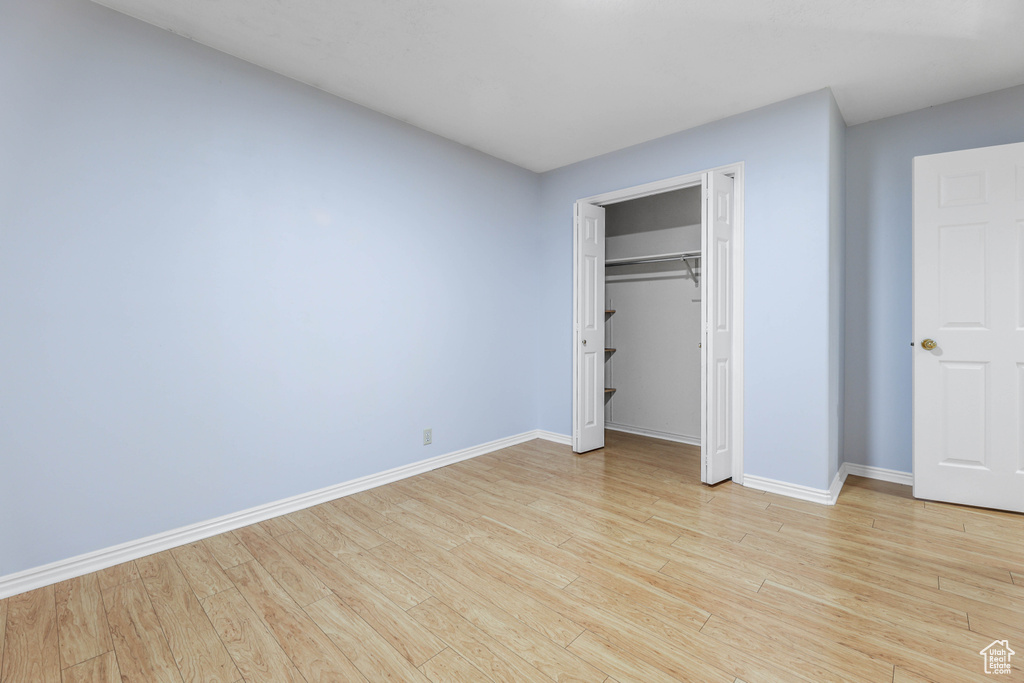 Unfurnished bedroom with baseboards and light wood-style flooring