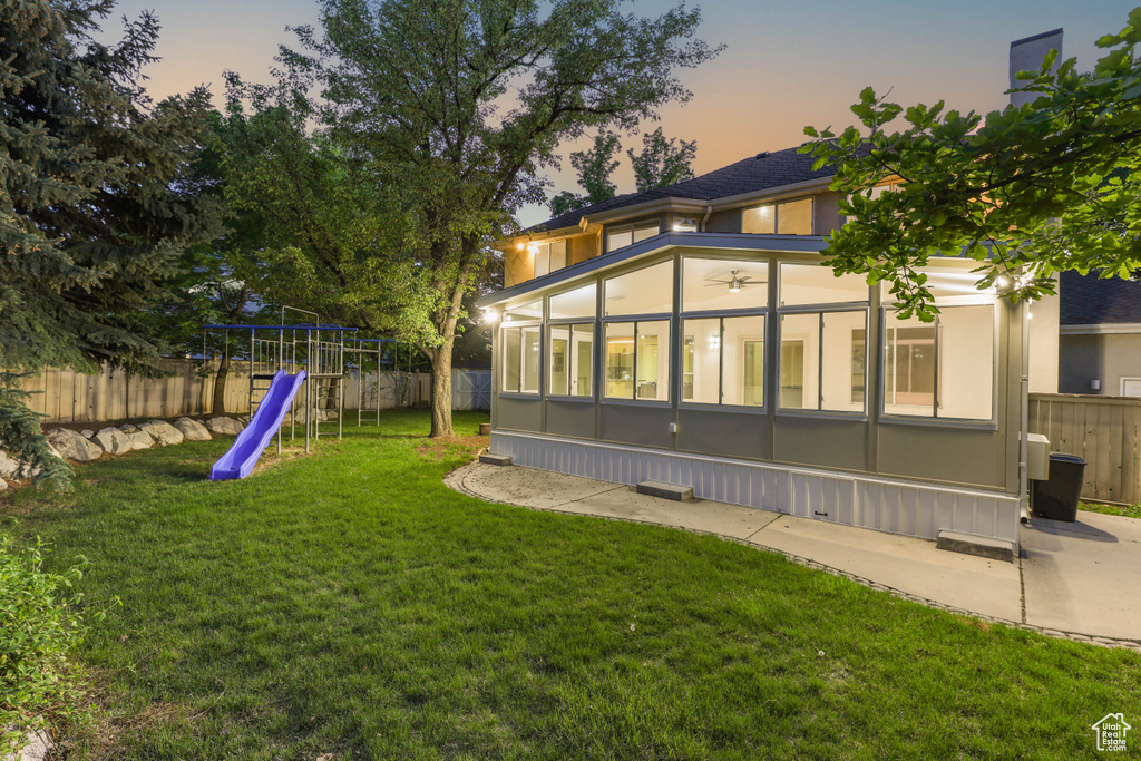 Back of property featuring a sunroom and a playground