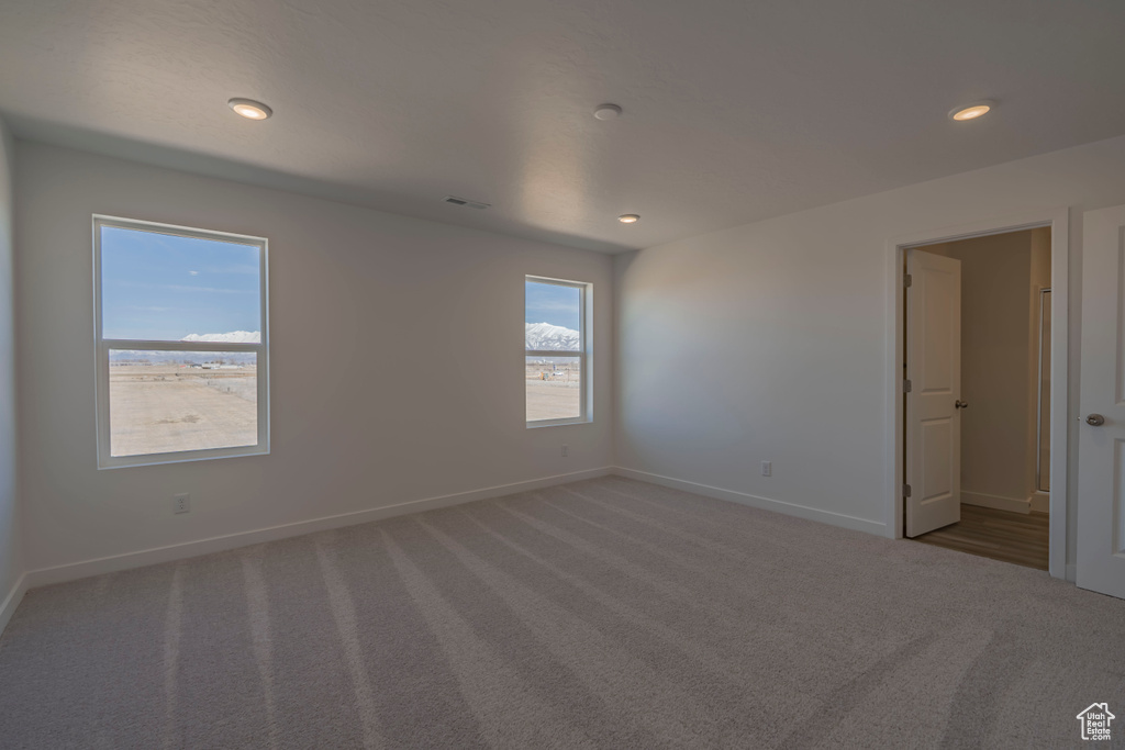 Carpeted empty room with baseboards and recessed lighting