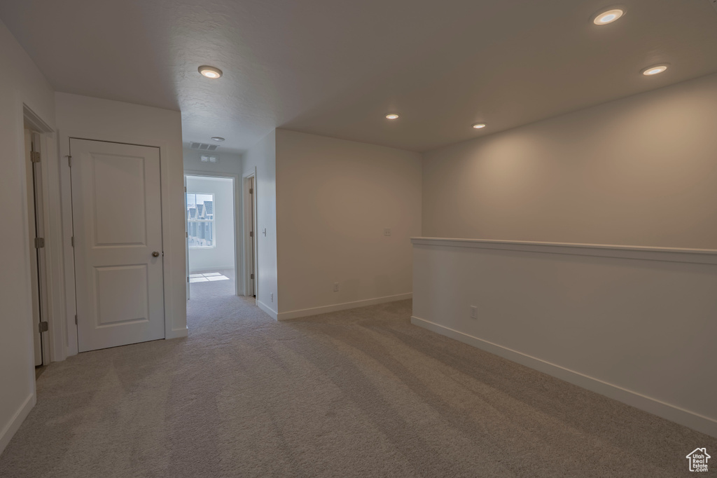Spare room with light colored carpet, baseboards, and recessed lighting
