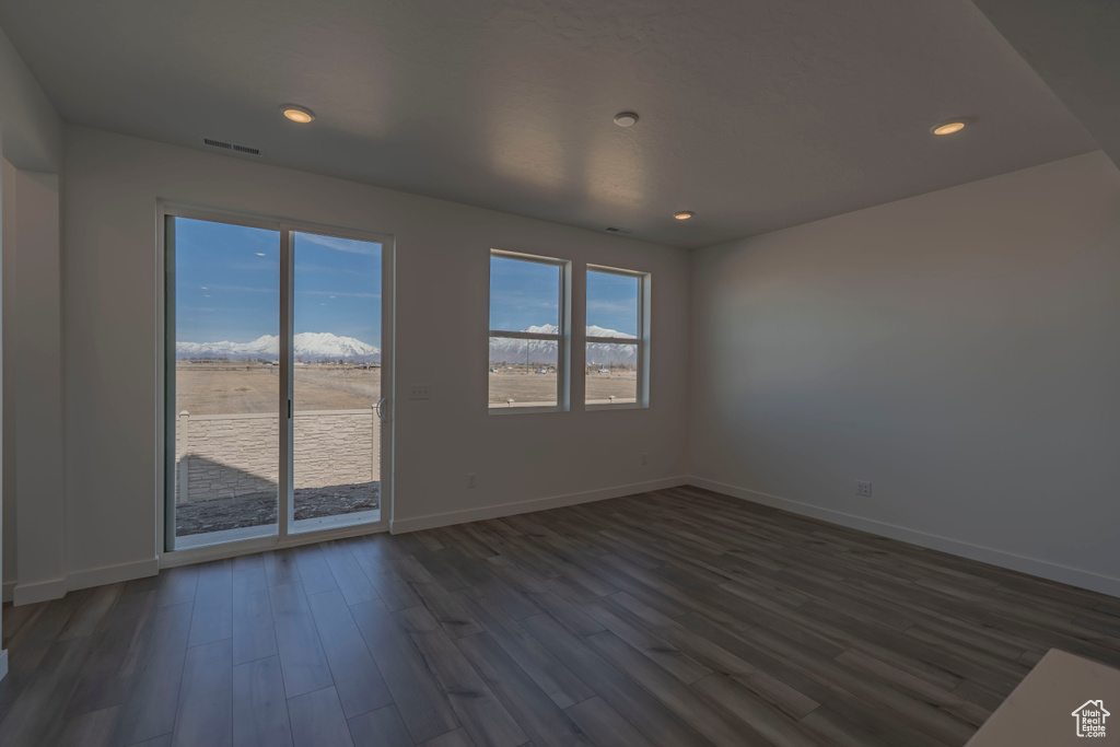 Unfurnished room with baseboards, dark wood finished floors, and recessed lighting