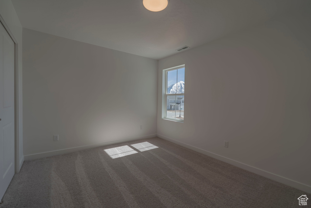 Carpeted empty room with baseboards