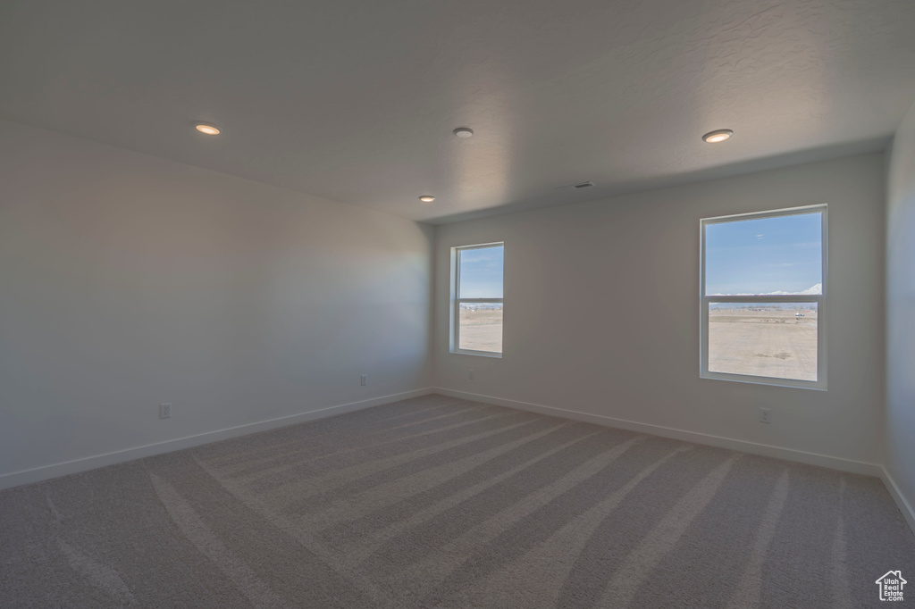 Unfurnished room featuring carpet flooring, baseboards, and recessed lighting