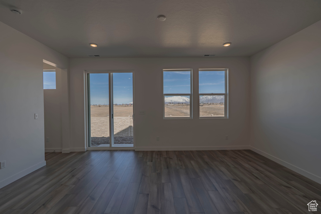 Unfurnished room with dark wood-style floors, baseboards, and recessed lighting