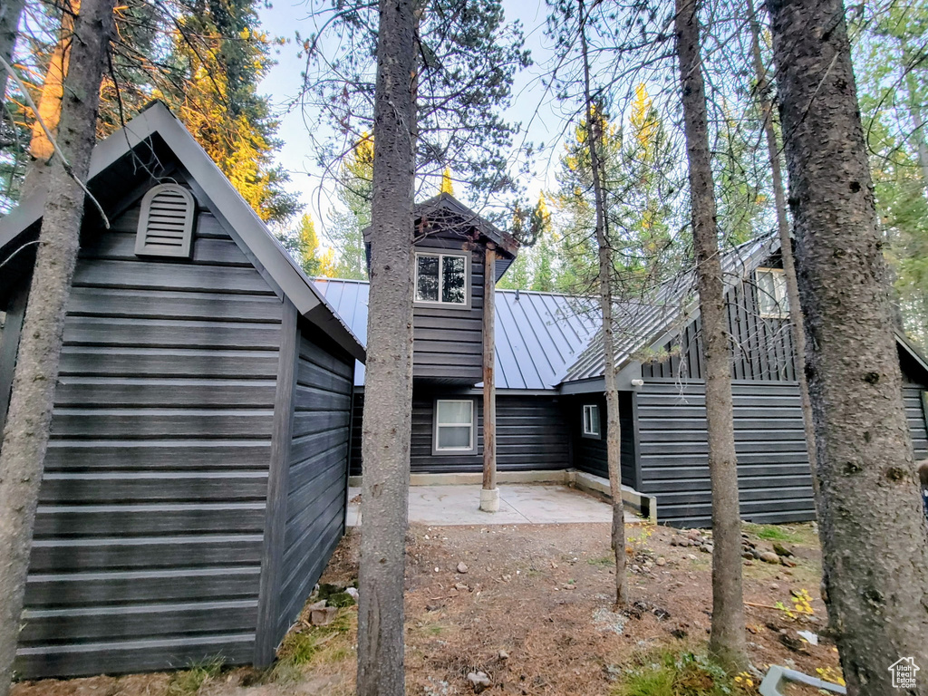 Rear view of property featuring a patio, metal roof, and a standing seam roof