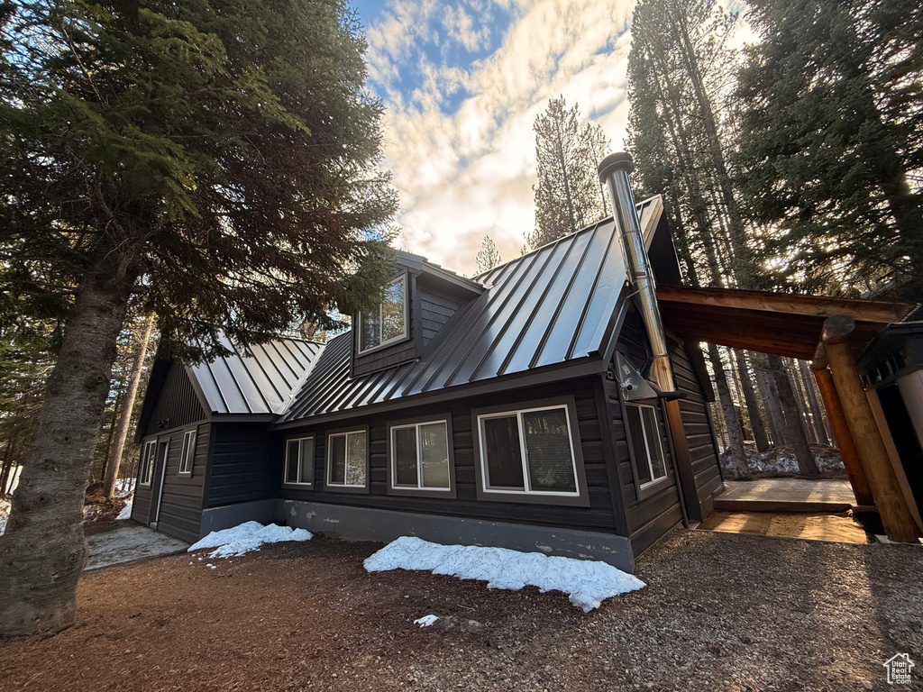 Rear view of house featuring a standing seam roof and metal roof