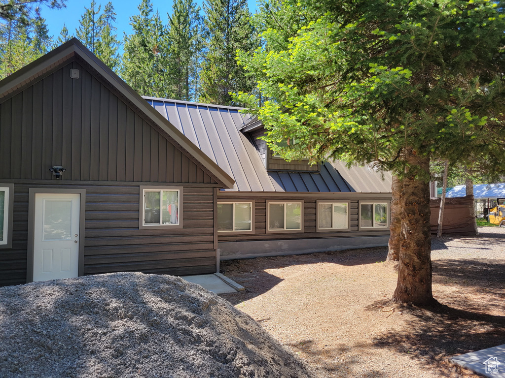 View of property exterior with a standing seam roof, metal roof, and board and batten siding