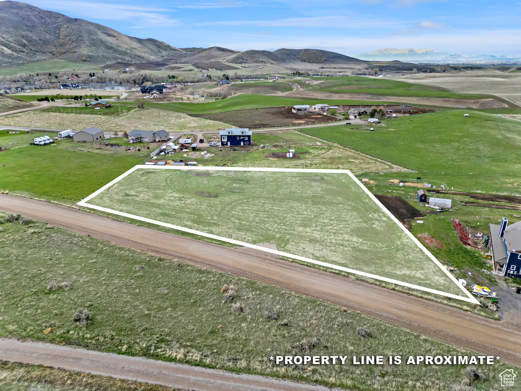 Aerial view of property and surrounding area featuring property boundaries highlighted and a mountain backdrop