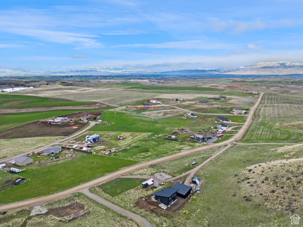 Aerial view of property and surrounding area featuring mountains and rural landscape