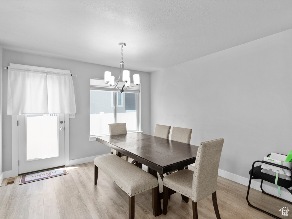 Dining area featuring a chandelier, light wood-type flooring, and baseboards