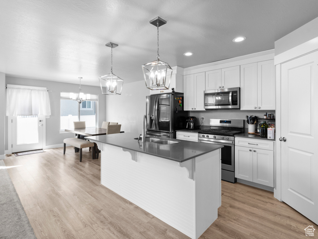 Kitchen featuring appliances with stainless steel finishes, a sink, a chandelier, recessed lighting, and dark countertops